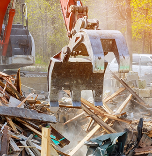 Demolition of an old house, wooden planks and rubble and the ruins of the house for new construction project.